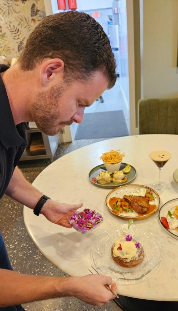 a man sitting at a table with plates of food