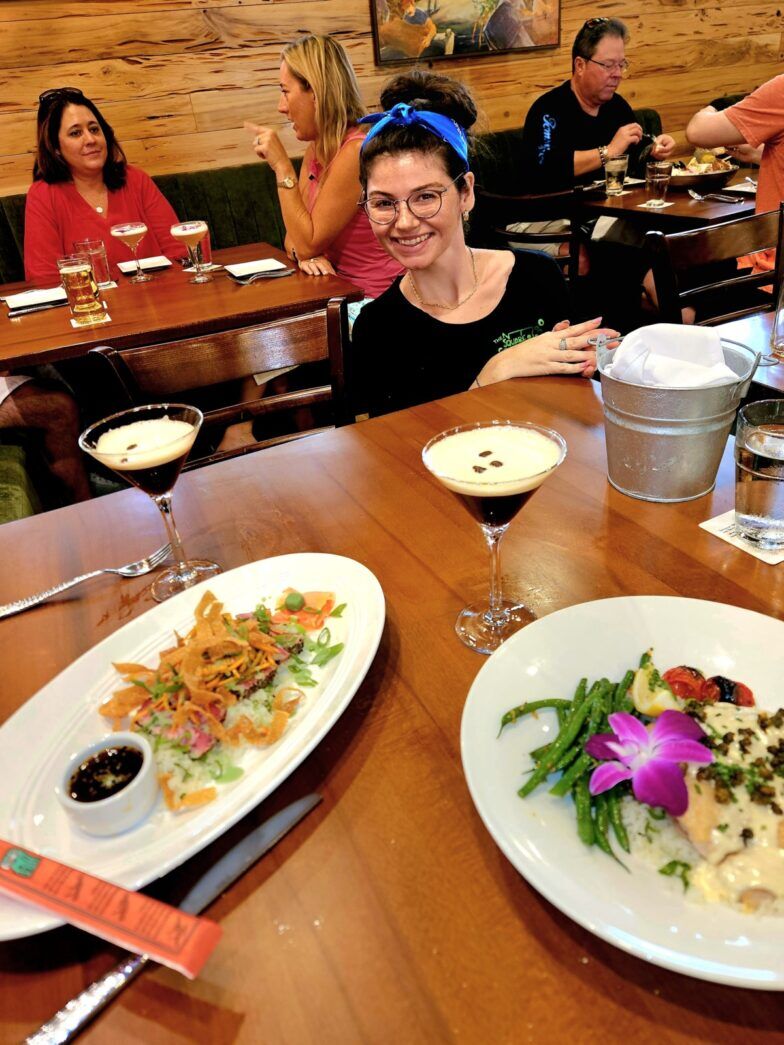 a group of people sitting at a table with plates of food