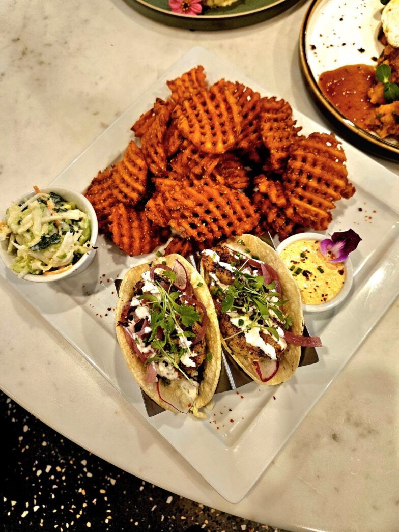 a table topped with plates of food and a bowl of dip