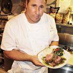 A man cooking in a kitchen preparing food - Chef