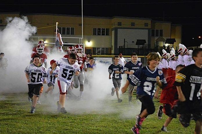 0425_YouthFootball1 web A group of people running on a field - Championship