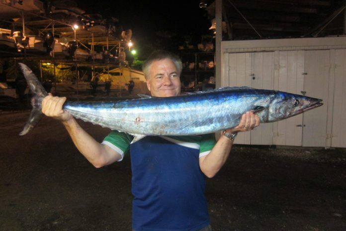1024_KWFISHING2 #Column: Try trolling at night - A young man holding a fish - Sardine