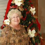 #SeenAroundTown: Festival of Tree culminates in Gala - A person standing next to a christmas tree - Christmas tree