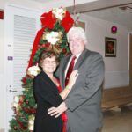 #SeenAroundTown: Festival of Tree culminates in Gala - A person wearing a red dress standing in a room - Christmas decoration