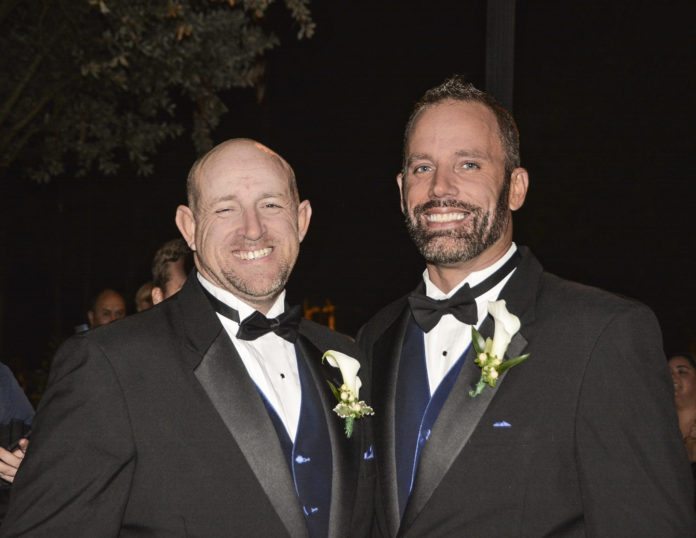 0213_GayExpo First Same-Sex Wedding Expo Set for Key West - A man wearing a suit and tie - Gourmet Nibbles & Baskets & Flowers