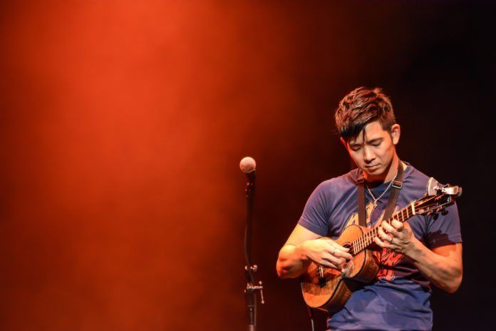 0909jake The Lord of the (4) Strings - Jake Shimabukuro standing on a stage holding a guitar - Jake Shimabukuro