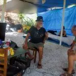 Wisteria Island: It’s complicated - A man sitting on a table - Wisteria Island