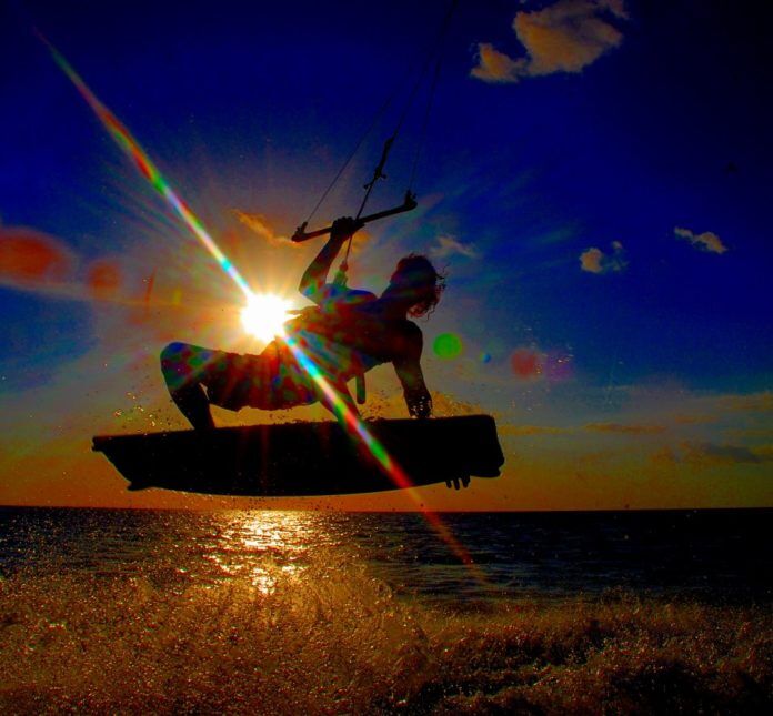 1207_Kiteboard2 Extra $1.6 million for tourism advertising - A person flying a kite in a boat on the water - Tourist Development Council