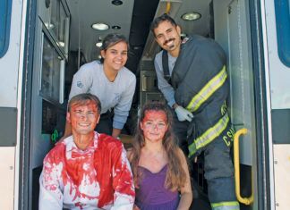 EMS and LEOs stage car accident before prom weekend Two-day party features swimsuit fashion show and axe throwing - A group of people standing around a bus - Car