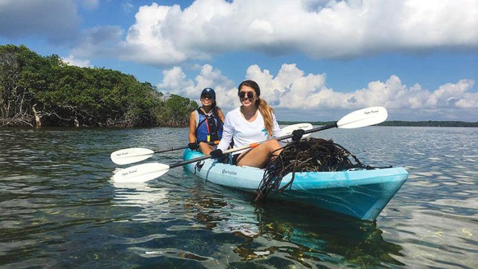 World Oceans Day Global day encourages better future for oceans - A person riding a surf board on a body of water - Sea kayak