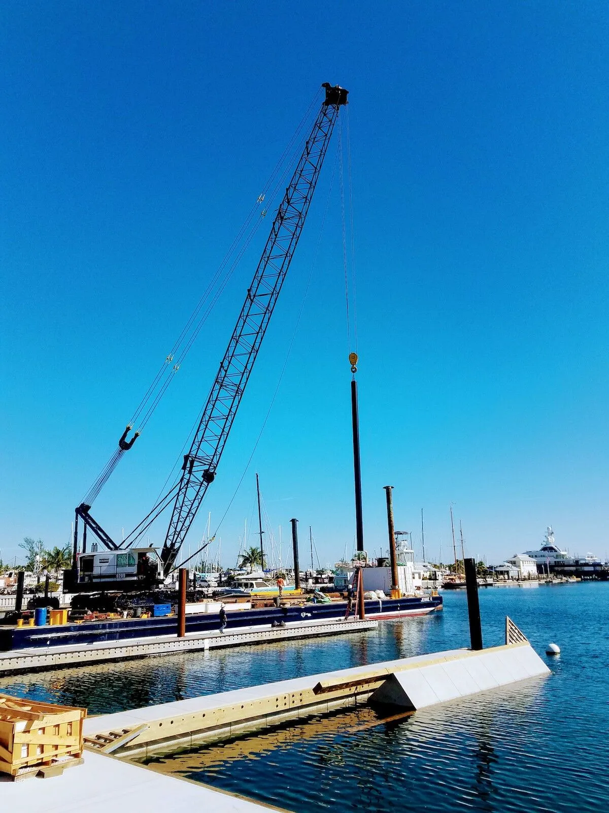 It takes a village… - A boat is docked next to a body of water - Crane vessel