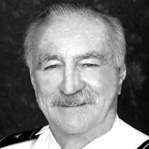 IN MEMORIAM 2019 - A man wearing a suit and tie smiling at the camera - Weekly newspaper