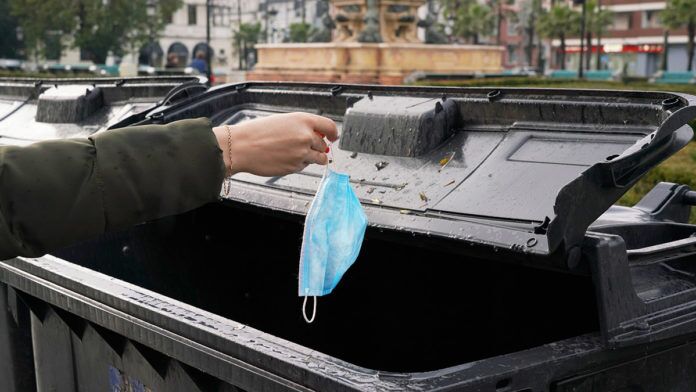 a person putting something in a trash can