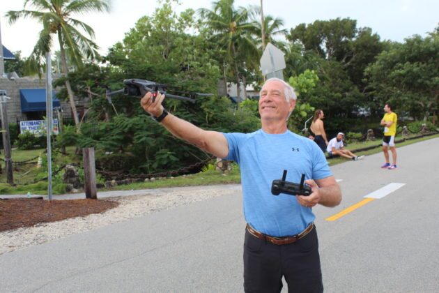 a man holding a camera and pointing to the sky