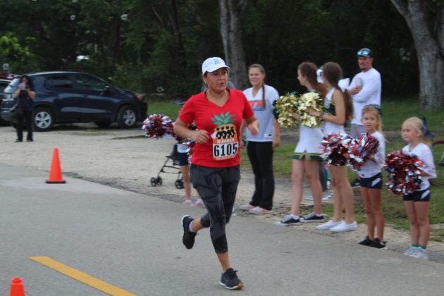 a man running down a street with cheerleaders behind him