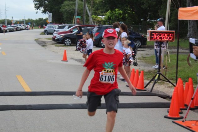 a young boy is running in a race