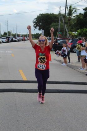 a woman in a red shirt is running in a race
