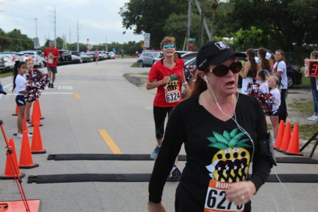 a woman in a black shirt running in a race