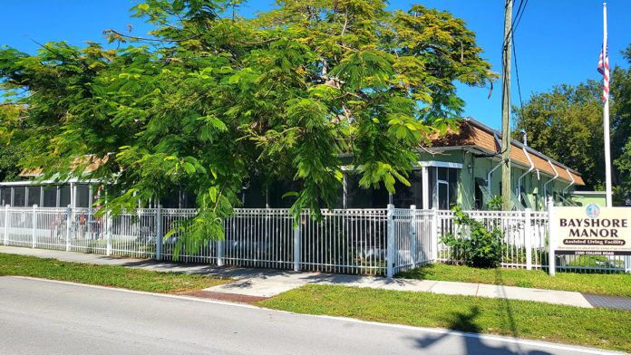 a small white house with a fence around it