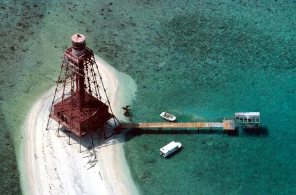 an aerial view of a lighthouse on a beach