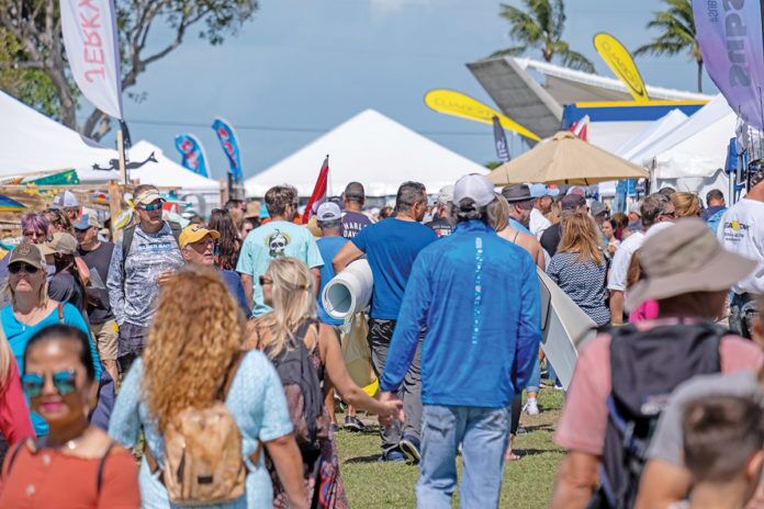 a crowd of people walking around a field