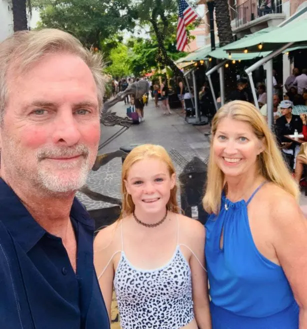 Barry-Gibson-&-family a man standing next to two women on a street