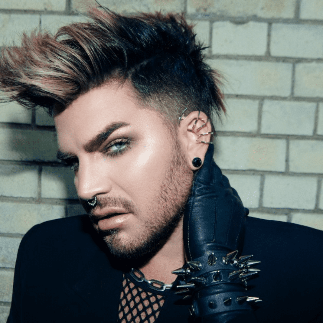 Adam Lambert a man with spiked hair wearing a black jacket and tie