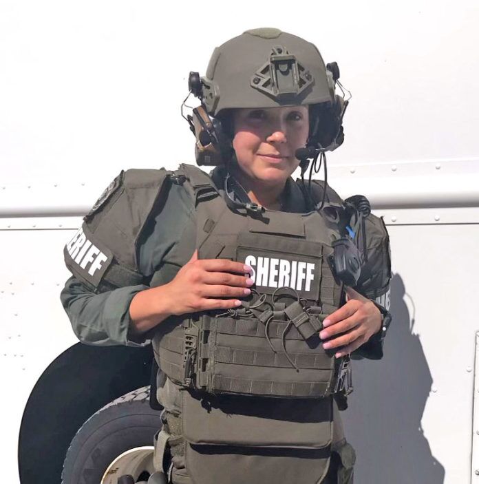 042822-Szymanski-SWAT a woman in a helmet and vest standing in front of a truck