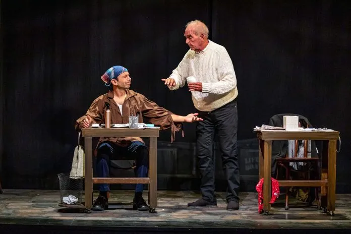 Life-in-Theater a man sitting at a table talking to another man