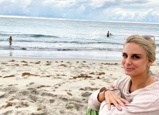 BEHIND THE BLONDE: GOODBYE, MY LOVER — A YEAR WITHOUT BOOZE a woman sitting on a beach next to the ocean