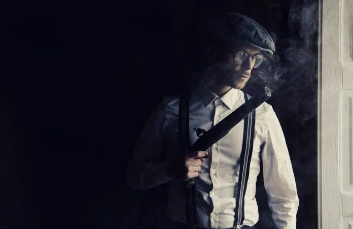 gun-g4d79d5368_1280 a man in a white shirt and tie smoking a cigarette