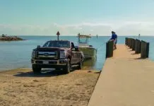 a truck parked on a dock next to a boat