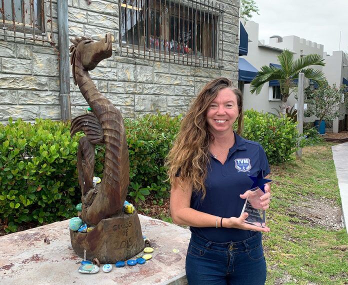 a woman standing next to a statue of a bird