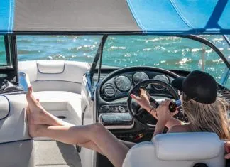 a woman is sitting in the driver's seat of a boat