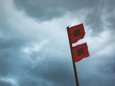 Screen Shot 2022-09-26 at 1.24.38 PM two red flags on a pole under a cloudy sky