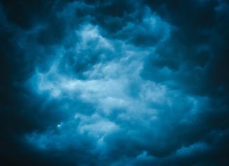 a dark blue sky with clouds in the background