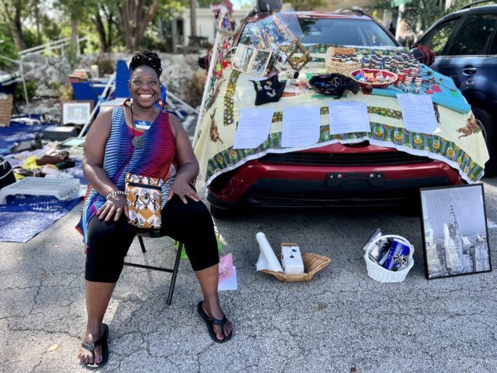 trunk-sale-jewelry a woman sitting in a chair next to a parked car