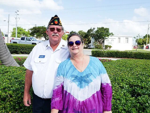 a man standing next to a woman in a tie dye dress