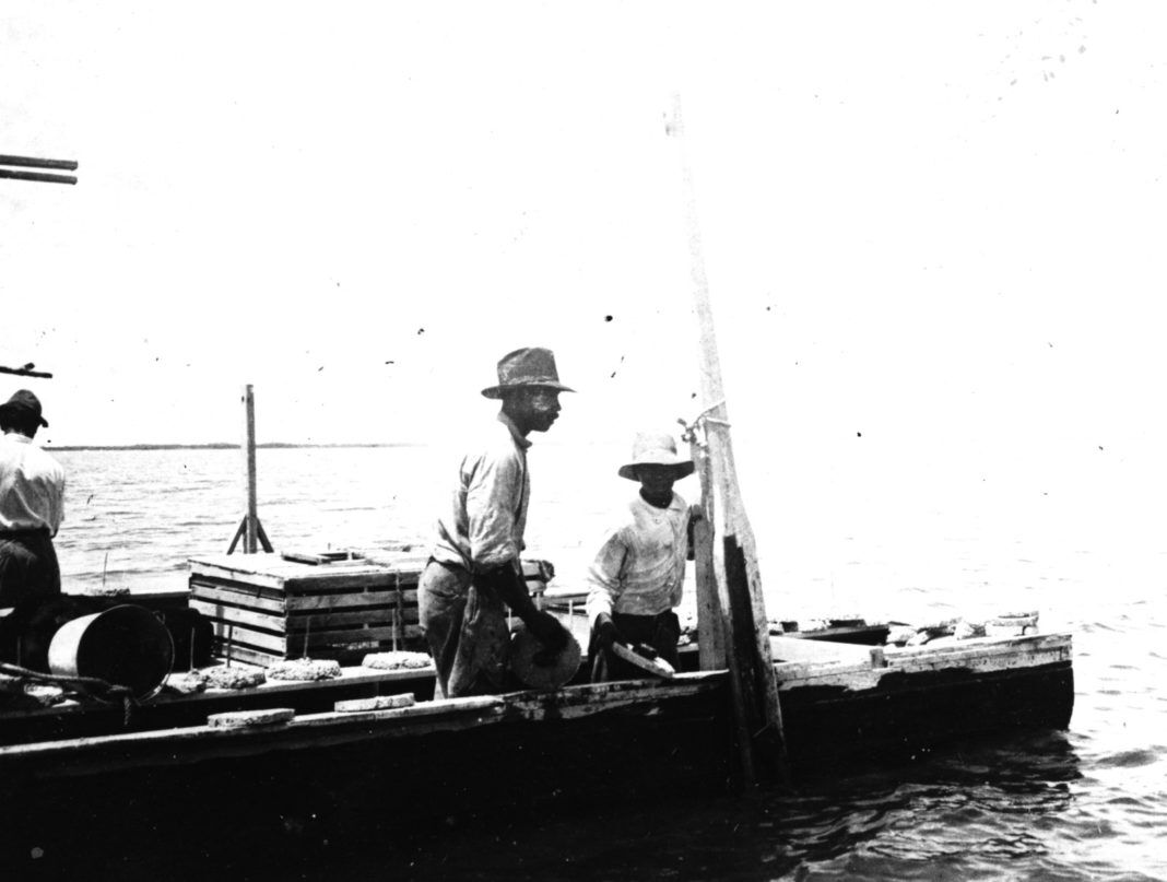 a group of men standing on top of a boat
