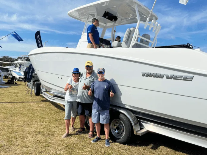 a group of people standing next to a white boat