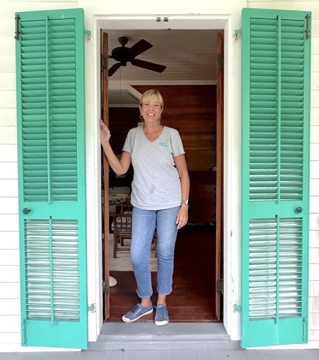 Sue Puskedra in door a woman standing in a doorway with green shutters