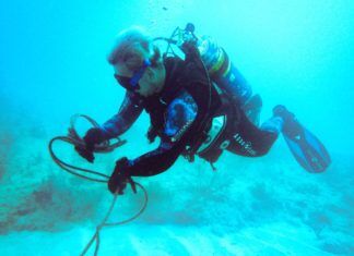 a man in a diving suit is holding a rope