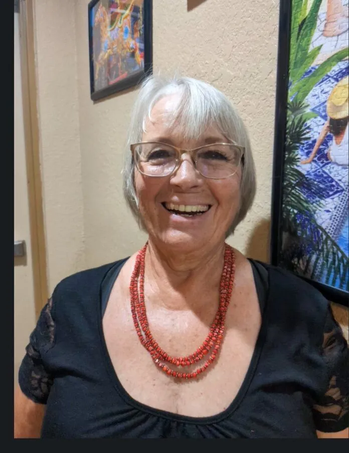 a woman wearing glasses and a red beaded necklace