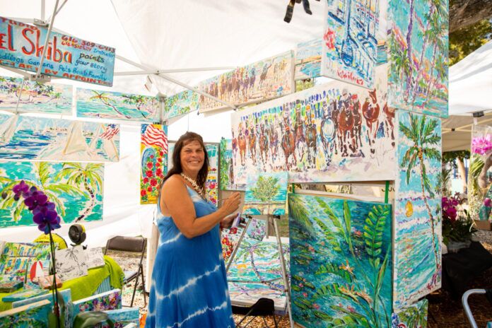 a woman standing in front of a display of art