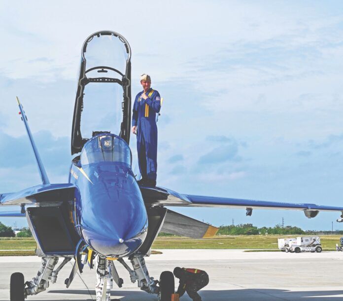 Blue Angels pilot fc Large a man standing next to a blue fighter jet