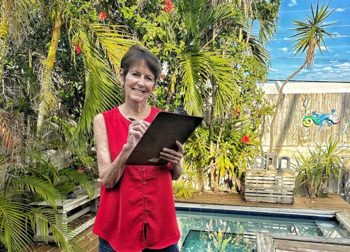 a woman standing in front of a pool holding a clipboard