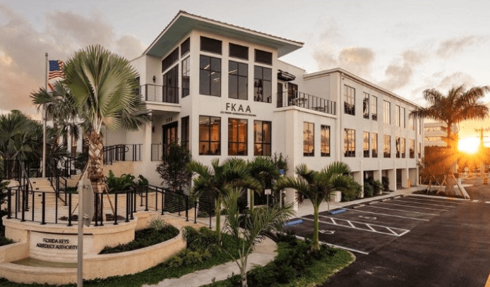 FKAA headquarters a large white building with palm trees in front of it