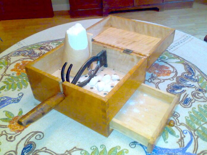 a wooden box with scissors in it on a table