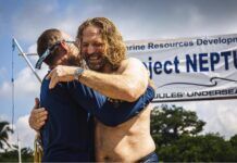 two men hugging each other in front of a sign