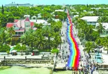 a long rainbow colored road going down a beach